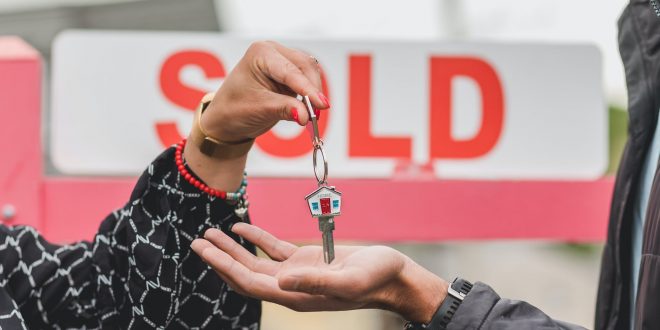 One person giving home keys to another person